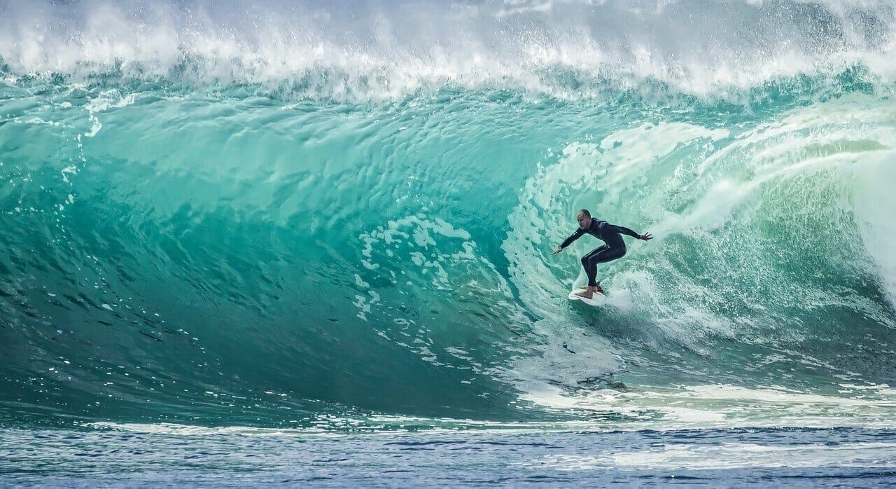 Surfer riding a large blue wave.